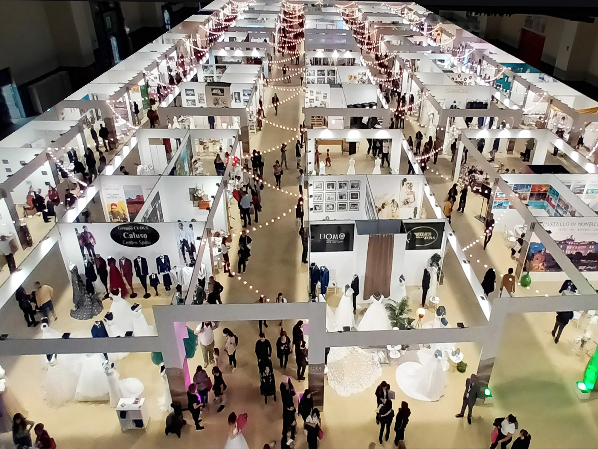 Coppia fra gli abiti da sposa a una fiera Sposi Club
